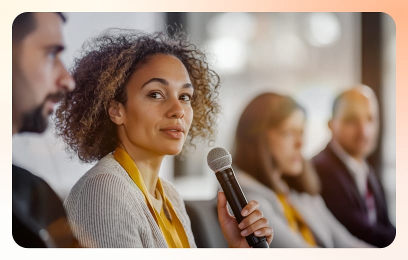 A panel speaker is speaking while holding a mic