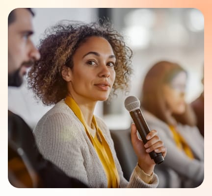 A panel speaker is speaking while holding a mic
