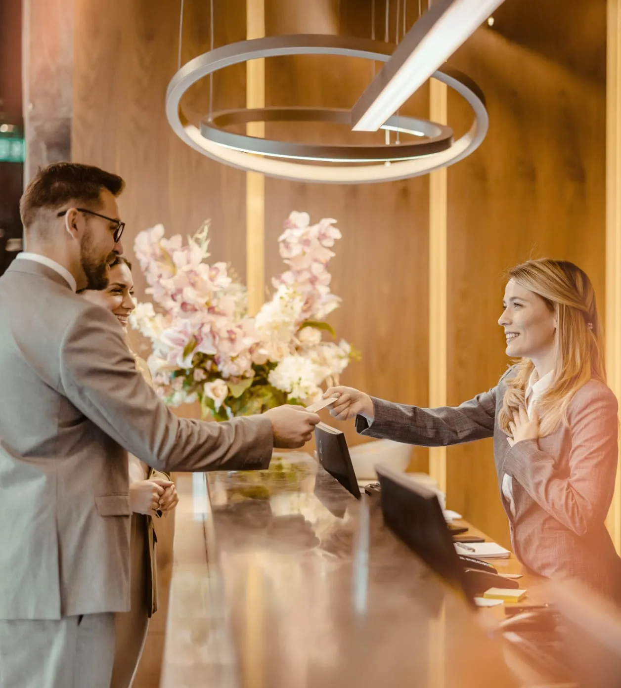 Hotel receptionist is handing room keys to a customer