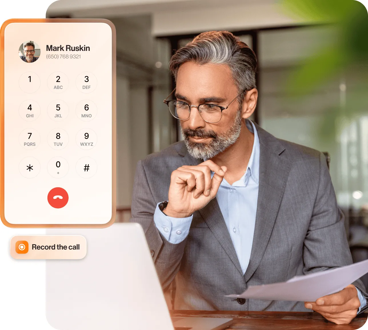 A man holding a paper while looking at his laptop with inlay of an incoming call and the Record the call option