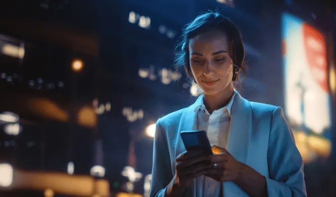 Whitepaper cover: A woman looking at her mobile phone