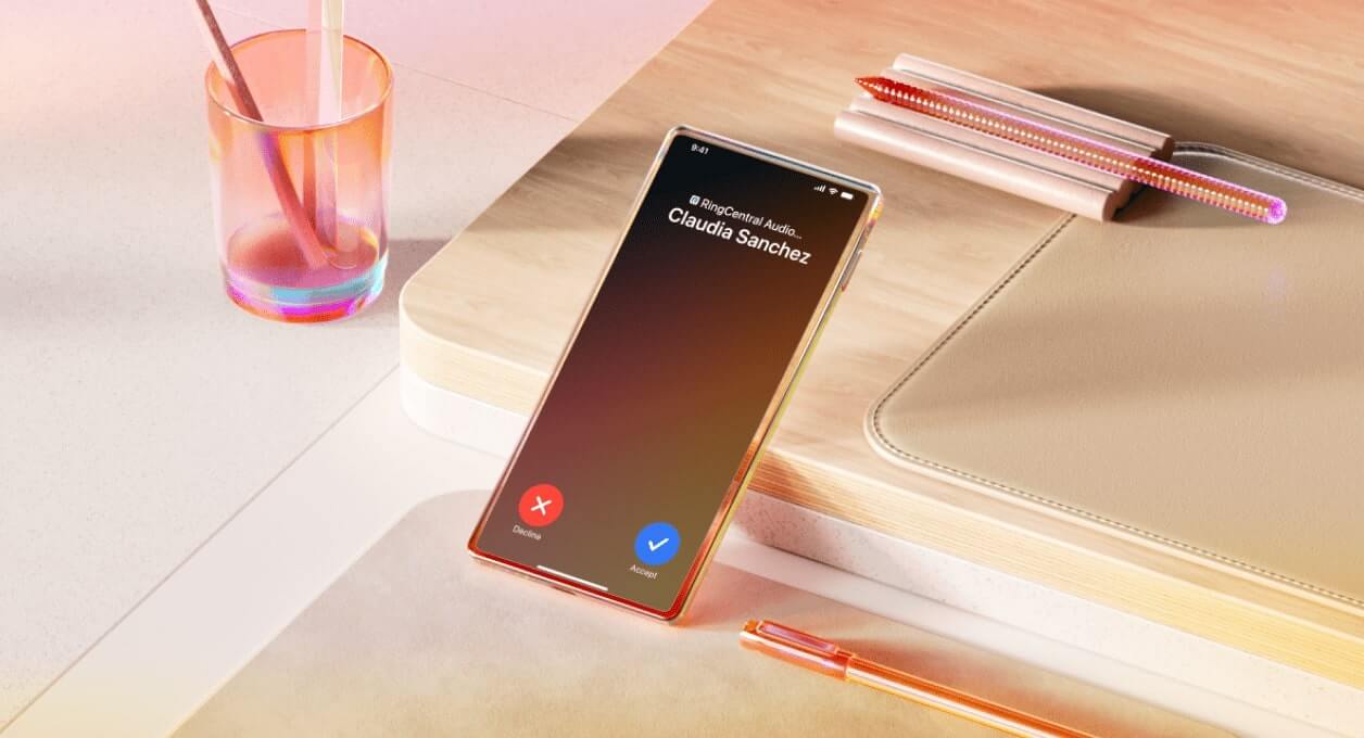 An incoming call notification from Claudia Sanchez on a mobile device in a wooden desk