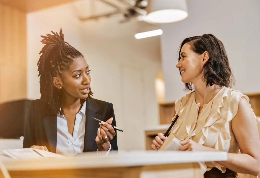 Two young professional women are in a discussion
